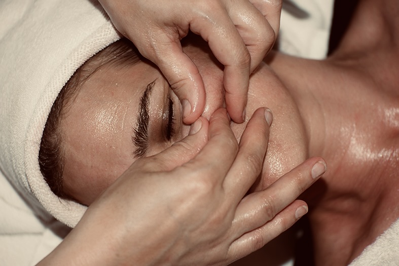 geste de massage kobido sur un visage féminin